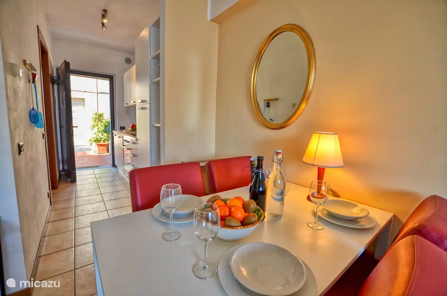 Mesa de comedor y cocina al fondo.