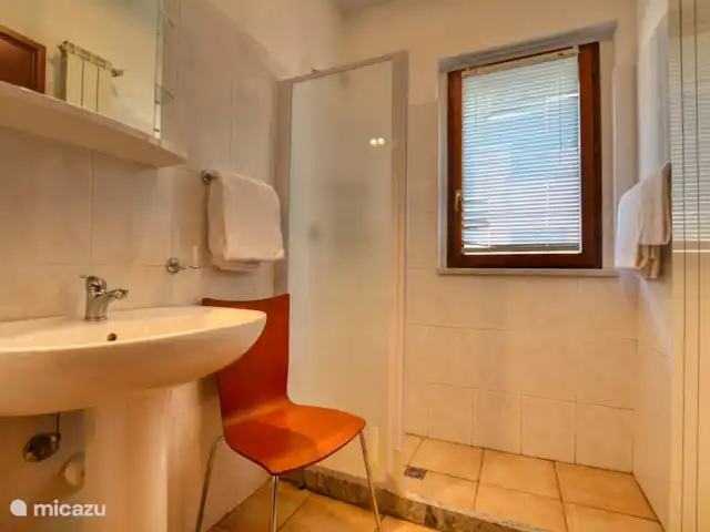 appartement huren in Italië, Comomeer, Acquaseria – Cipresso 33 De badkamer op de begane grond met douche, wastafel en aparte afgescheiden toiletruimte.