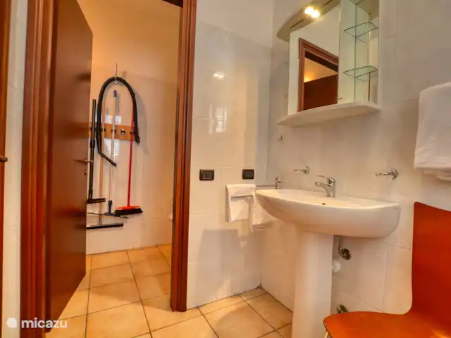 appartement huren in Italië, Comomeer, Acquaseria – Cipresso 33 De badkamer op de begane grond met douche, wastafel en aparte afgescheiden toiletruimte.
