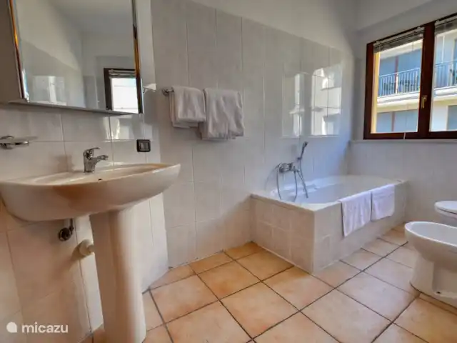 appartement huren in Italië, Comomeer, Acquaseria – Cipresso 33 De badkamer boven is riant bemeten en beschikt over een ligbad, wastafel, wasmachine (nog niet op de foto) en toilet.