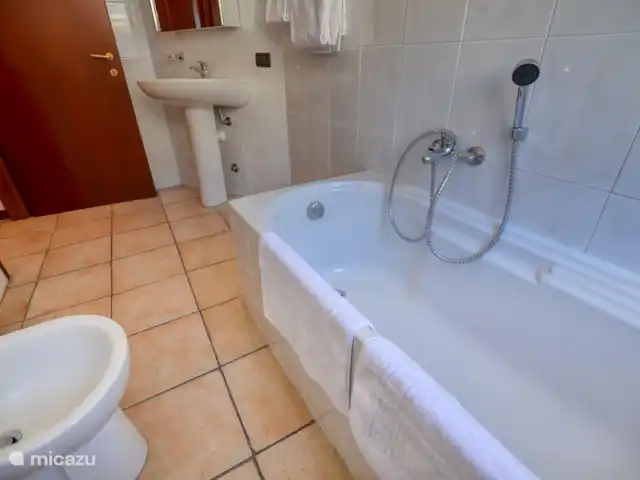 appartement huren in Italië, Comomeer, Acquaseria – Cipresso 33 De badkamer boven is riant bemeten en beschikt over een ligbad, wastafel, wasmachine (nog niet op de foto) en toilet.