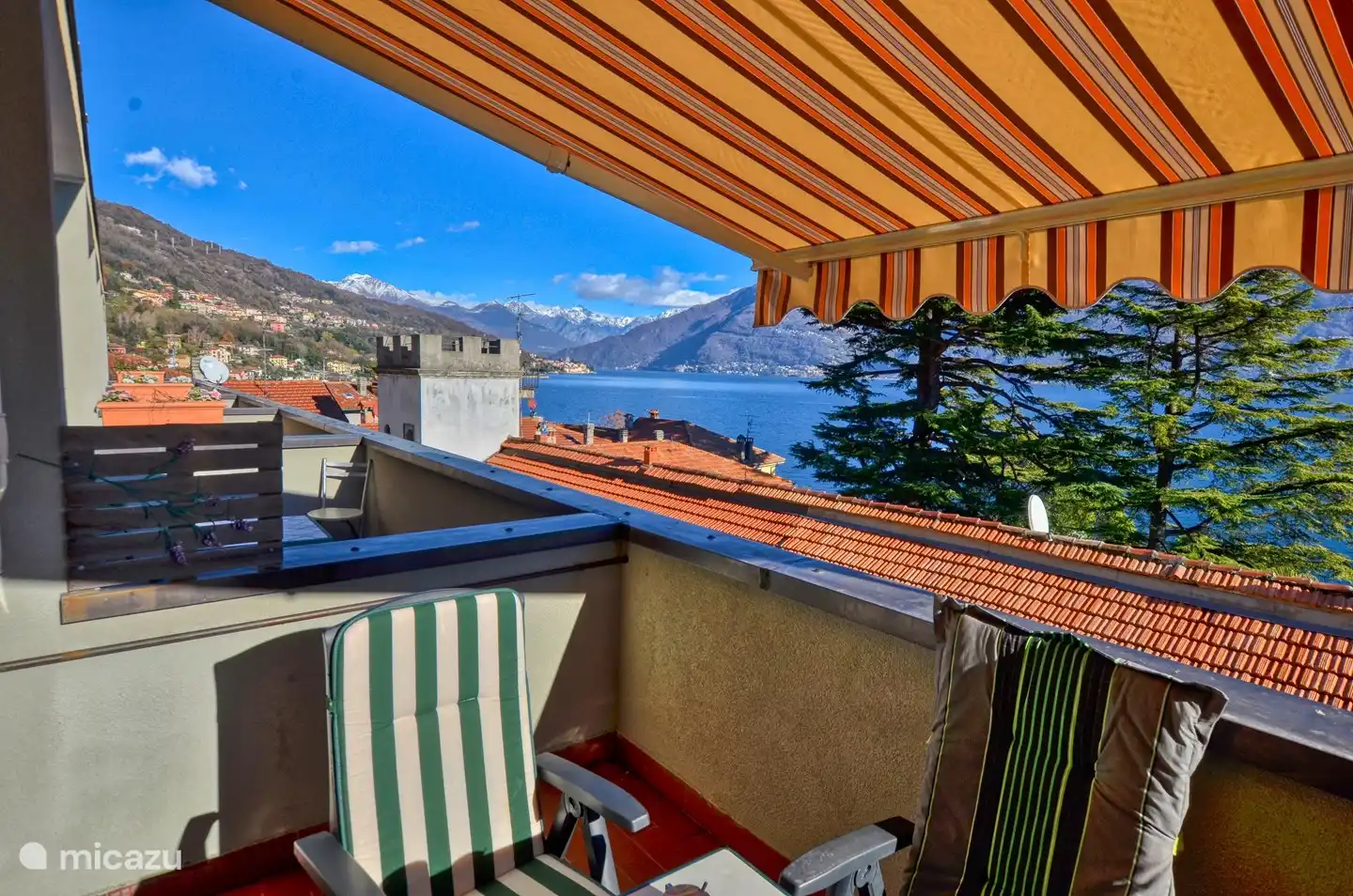Vista del lado izquierdo. El amplio balcón con hermosa vista al lago, muebles de exterior y toldo eléctrico. Maravillosa estancia aquí.