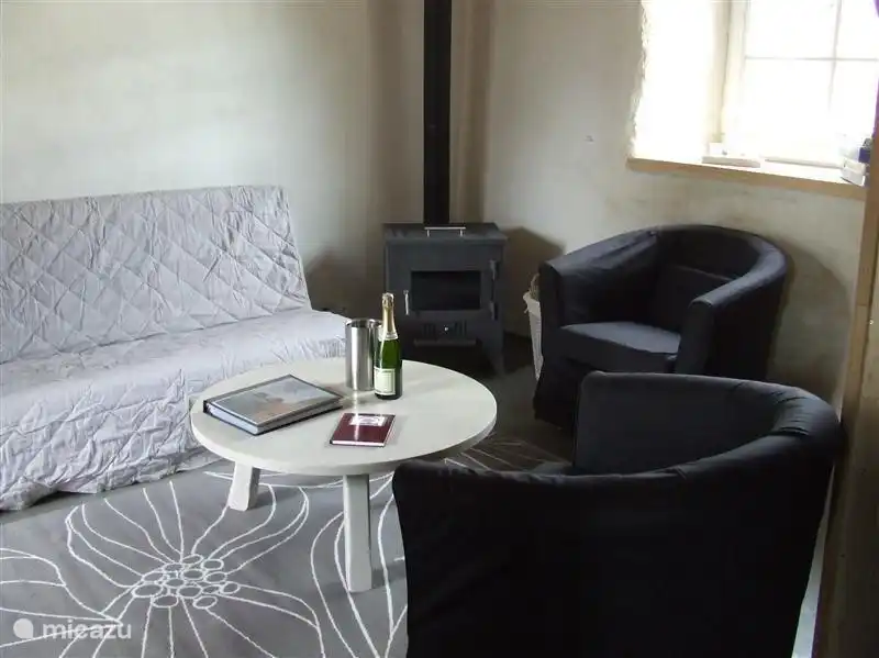 De huiskamer van de varkensstal met houtkachel en over de hele vloer is aardwarmte.