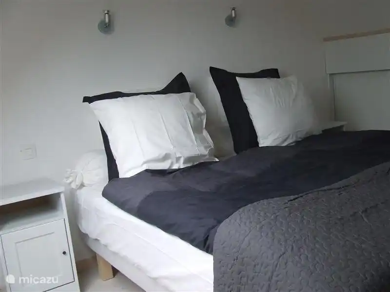 De ouderslaapkamer van de varkensstal met boxspringbedden (hotelkwaliteit) met dekmatras, dekbedden en vier kussens zorgen voor een goede nachtrust.