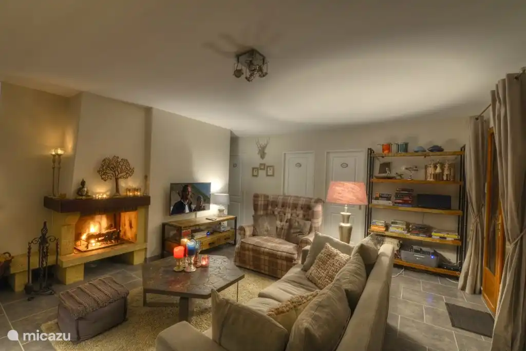 Sfeer beeld van de woonkamer in de avond met openhaard