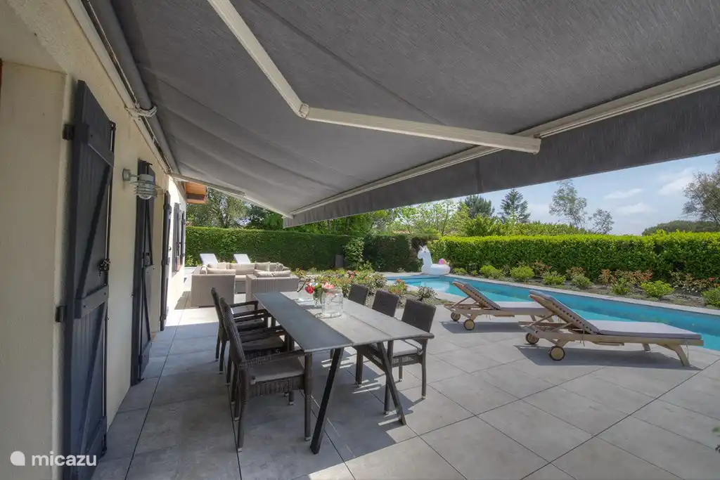 Buiten eettafel met uitzicht op de tuin en het zwembad