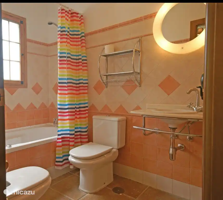 Baño adyacente al dormitorio 1 con baño de burbujas, inodoro, bidé y lavabo.