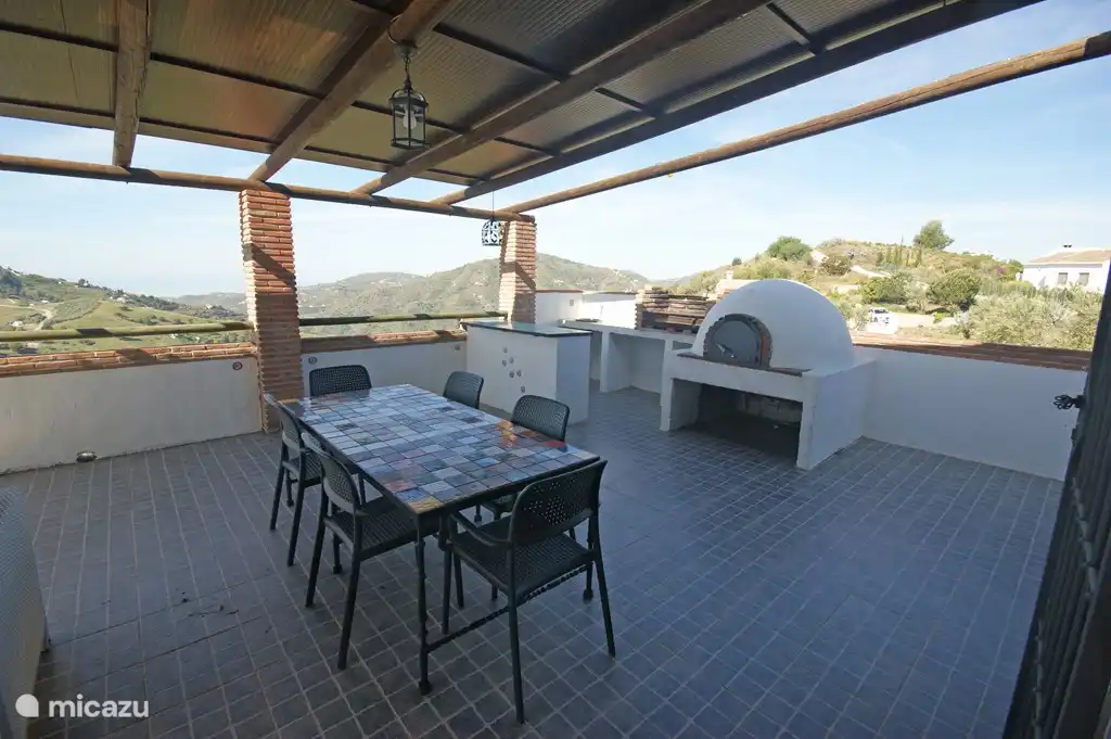 Una barbacoa y un horno de leña para pizzas garantizan veladas de deliciosa y acogedora cocina juntos.