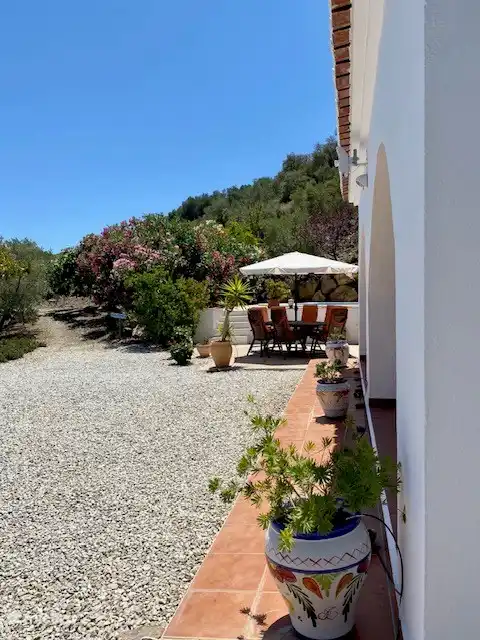 Regardez au-delà de la terrasse couverte sur la table avec des chaises sur la terrasse ouverte et la Calle de La Luz