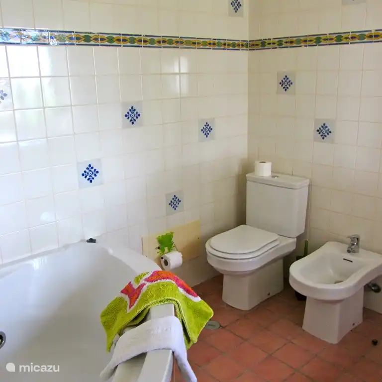 Salle de bain avec grande baignoire d'angle et décorée de carreaux muraux portugais