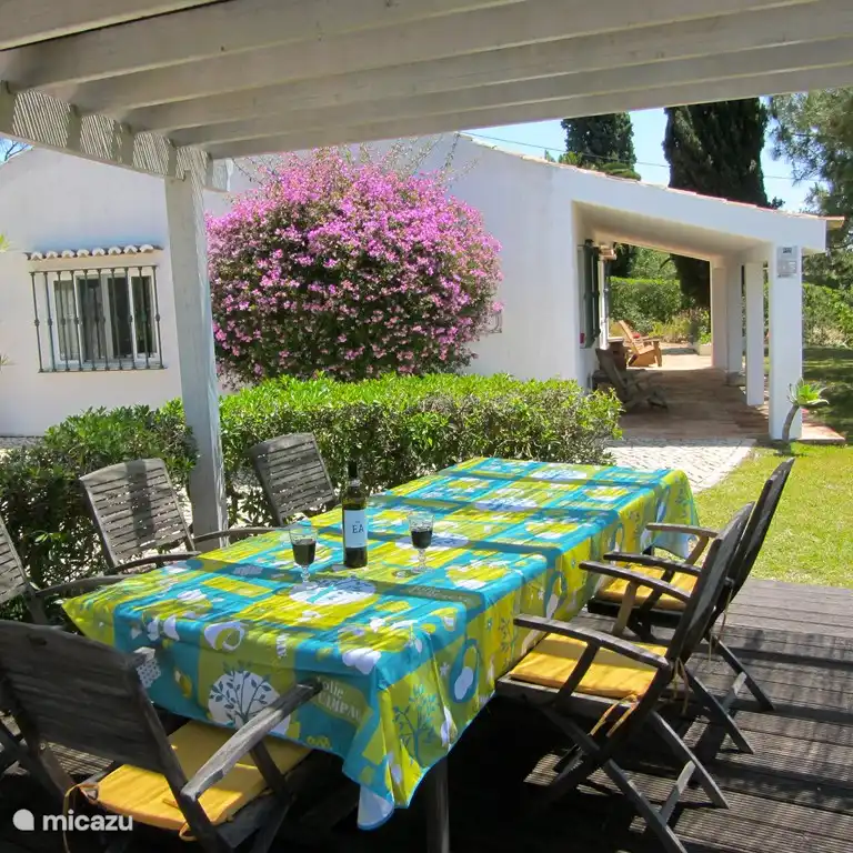 Table à manger spacieuse sous pergola sur la terrasse avec vue sur la mer