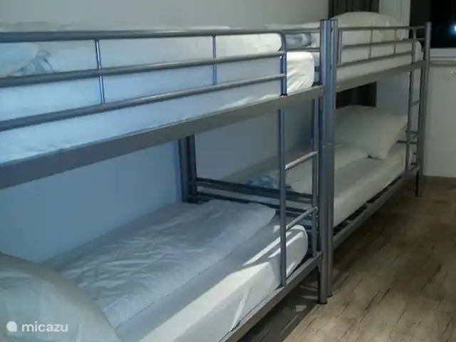 Aineckblick TOP 14 | Autriche, Salzburgerland, Sankt Margarethen im Lungau - appartement Chambre avec 2 lits superposés (4 couchages). Chaque lieu de couchage a sa propre lampe à pince inclinable et une étagère pour mettre un téléphone portable, un livre ou d'autres choses.
Le placard ouvert offre beaucoup d'espace de rangement pour les valises/sacs/vêtements. Les crochets sont également attachés