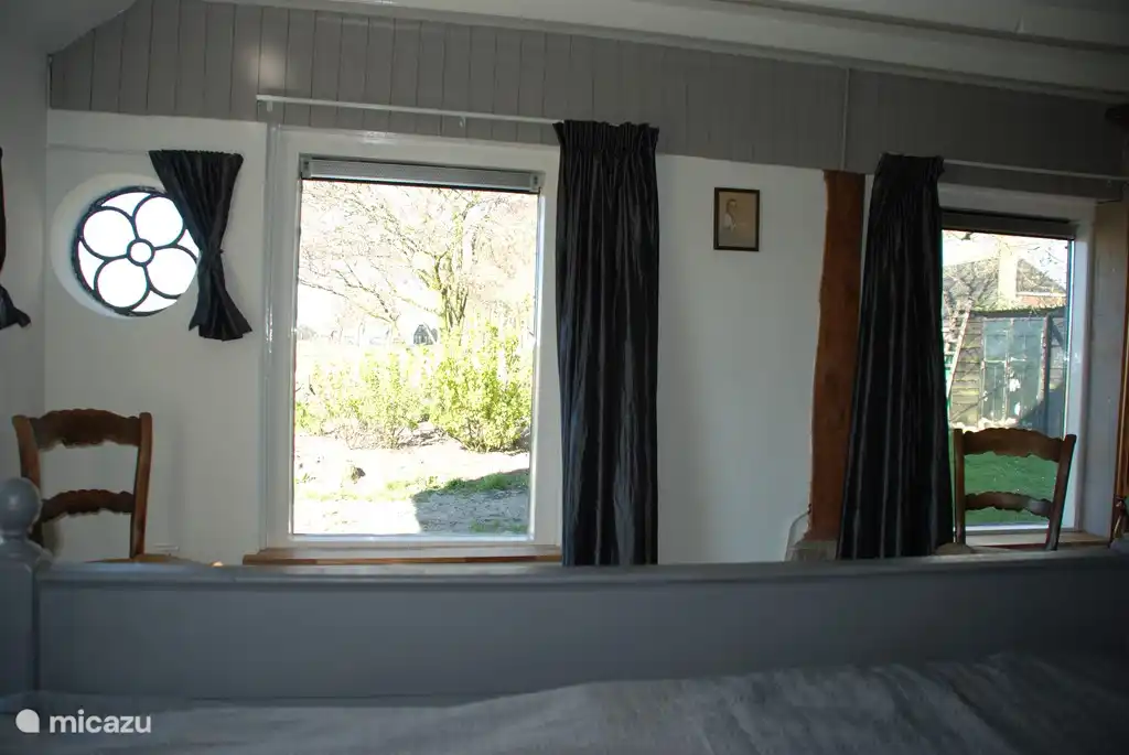 Masterbedroom met uitzicht op tuin en landerijen vanuit bed.