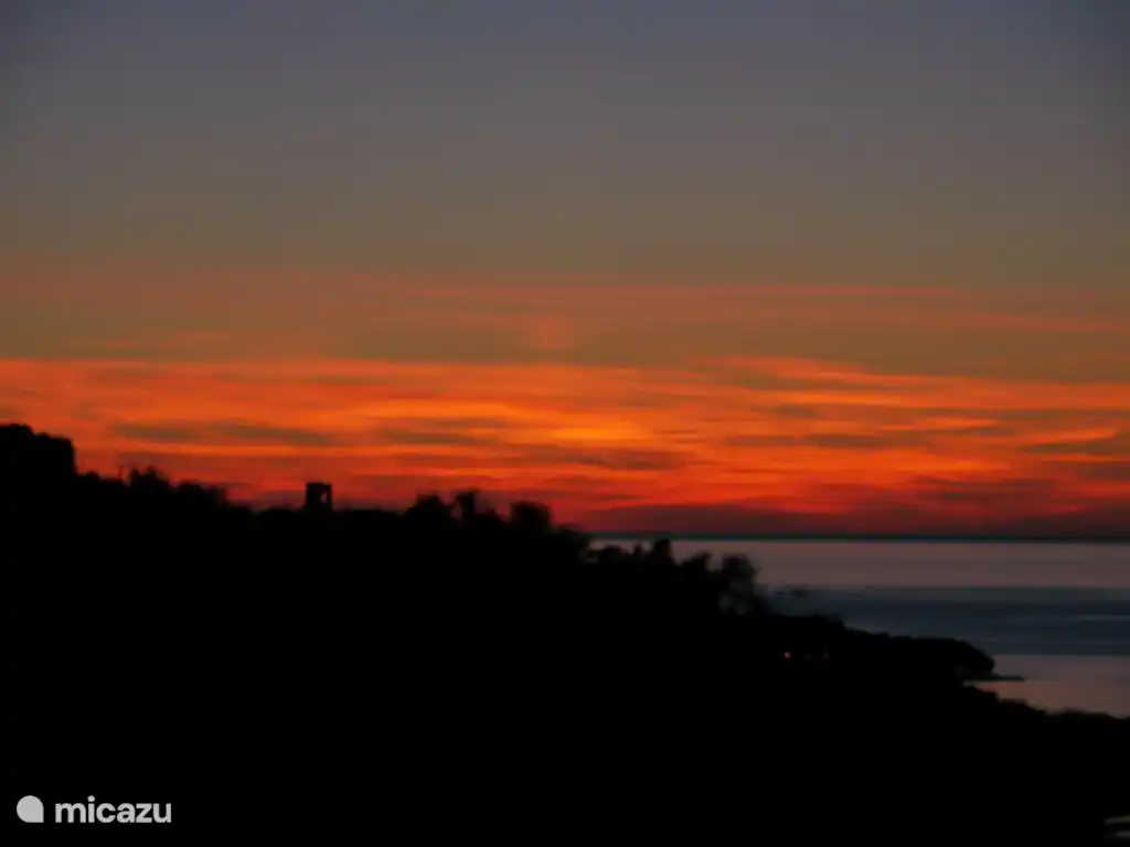 sunset with the Genoese tower and the sea and mountain from the garden