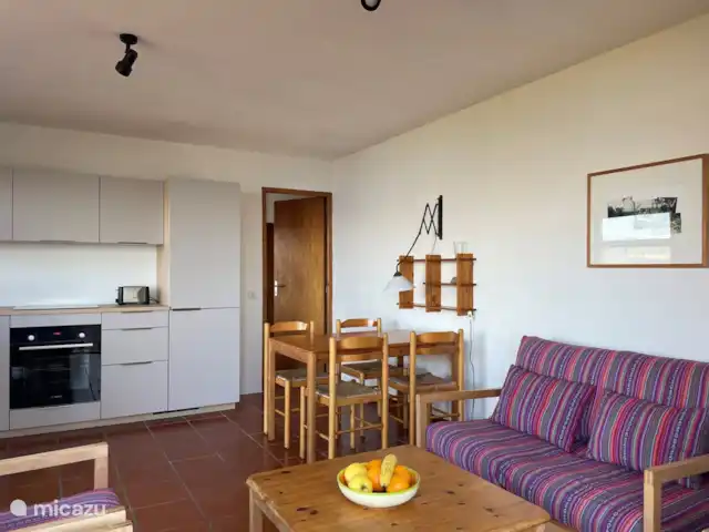 casa vacacional en Francia, Córcega, Calcatoggio – Villa Arbousier Calcatoggio Sala de estar con cocina y puerta al dormitorio.