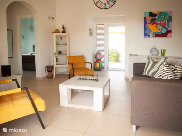 Casa Kontentu en Curazao, Bandabou (oeste), Fontein - casa vacacional el salón está amueblado con un sofá y 2 sillones. Además, un mueble de televisión y una cómoda. Por supuesto, también se incluyen un televisor, un cine en casa y un reproductor de DVD. Se ha instalado un ventilador de techo para refrescarse.