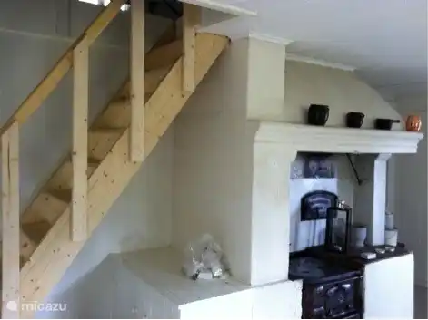 Kitchen with stove and 19th century wooden staircase to the top floor.