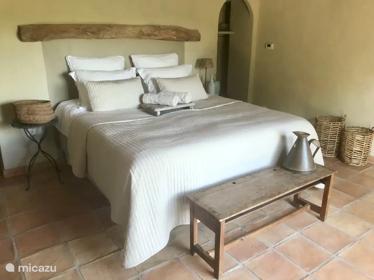 El precioso dormitorio principal grande con un somier precioso. A través del arco entras en tu propio baño. El dormitorio tiene puertas de patio para que tengas una vista preciosa del valle por la mañana y te despiertes con el canto de los pájaros de fondo.