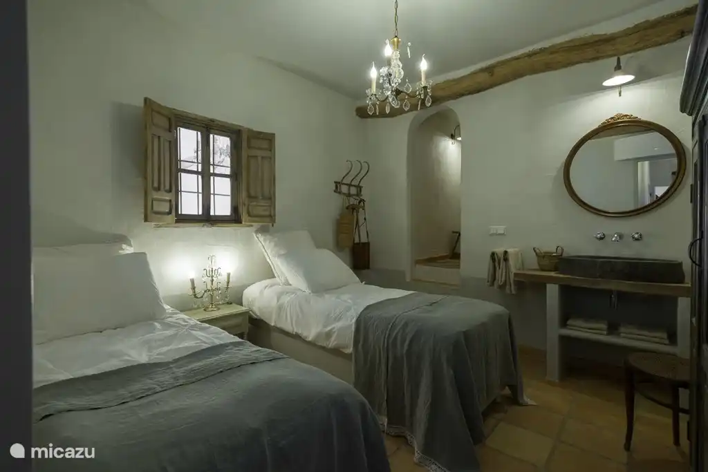 El dormitorio en la planta baja con dos camas individuales. A través de las escaleras se accede a la cabina de ducha con ducha que puede iluminar el baño en todo tipo de colores mientras se ducha, lo que es muy agradable para los niños, por ejemplo.