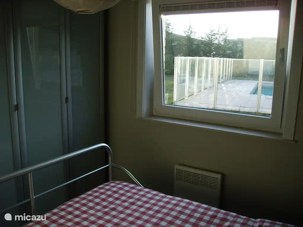 slaapkamer met zicht op de tuin en het zwembad