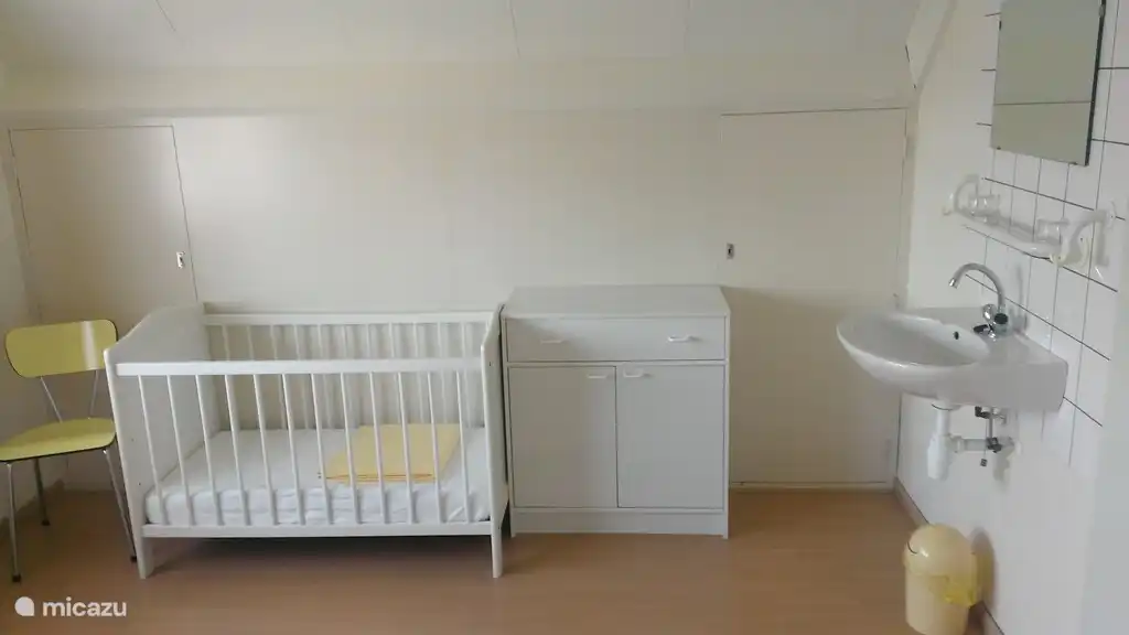 Large master bedroom with cot and changing