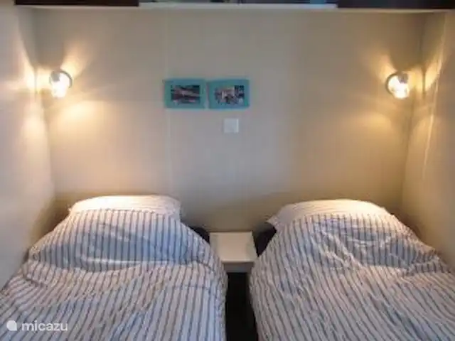 Pampelonne mobilhome aan het strand huren in Frankrijk, Côte d´Azur, Ramatuelle - stacaravan Slaapkamer drie met twee eenpersoonsbedden (80 cm breed). (kunnen ook aan elkaar worden geschoven voor 2 persoonsbed).
In de hoek een kledingkast met hang/leg ruimte, boven de bedden een legkast.
Een hor rolgordijn voor het raam om het ongedierte buiten te houden.