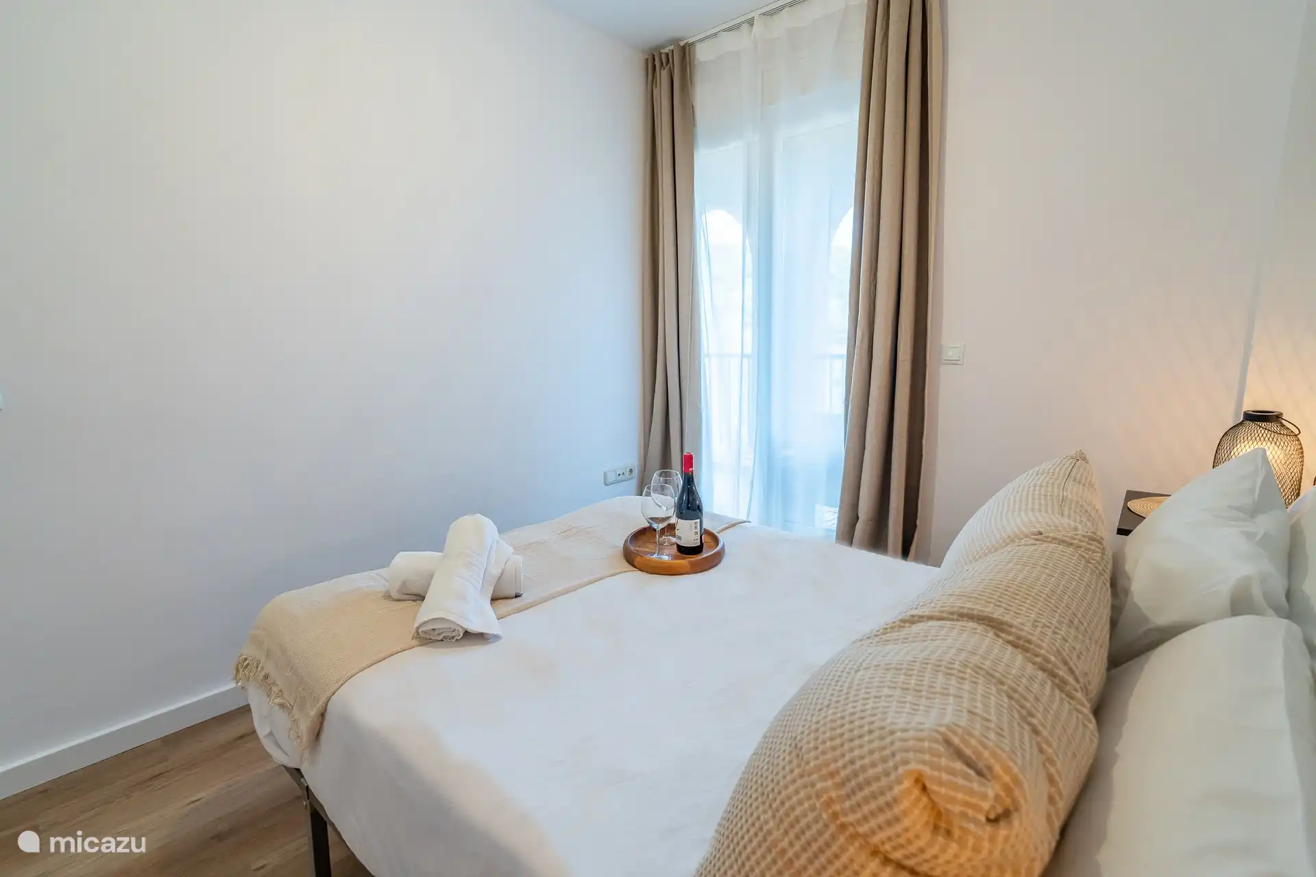 Schlafzimmer mit Doppelbett und Zugang zur Terrasse.