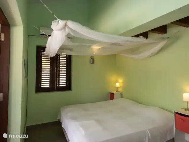villa huren in Bonaire, Bonaire, Belnem – Cas Bon Majeti De slaapkamers  zijn voorzien van airconditioning, ventilatie, grote klamboe, zitje en kledingkast en hebben een directe toegang tot een van de porches en tot een eigen badkamer met douche en toilet.