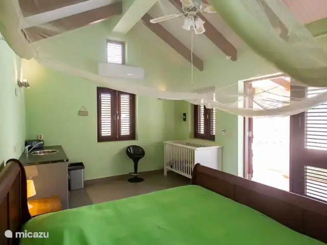 villa huren in Bonaire, Bonaire, Belnem – Cas Bon Majeti De separate studio met airconditioning bevat 2 een groot 2-persoonsbed, een bergkast, een douche en toilet, een keuken en zitjes.