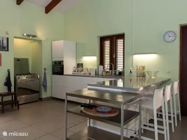 villa huren in Bonaire, Bonaire, Belnem – Cas Bon Majeti Ruime woonkamer en keuken met koelkast/vriezer, vaatwasser, 6-pits gasfornuis, combimagnetron en trolley om al uw bereide etenswaren in één keer mee te nemen.