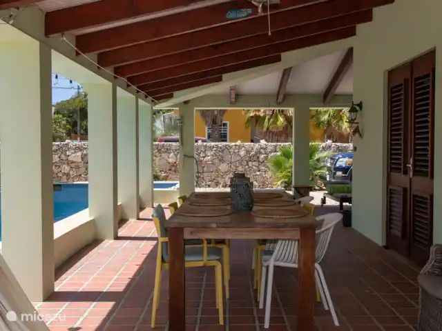 villa huren in Bonaire, Bonaire, Belnem – Cas Bon Majeti De grote porch, uw vaste stek! Grote tafel met comfortabele stoelen. Tevens meerdere ligstoelen en buitendouche t.b.v. het zwembad.
