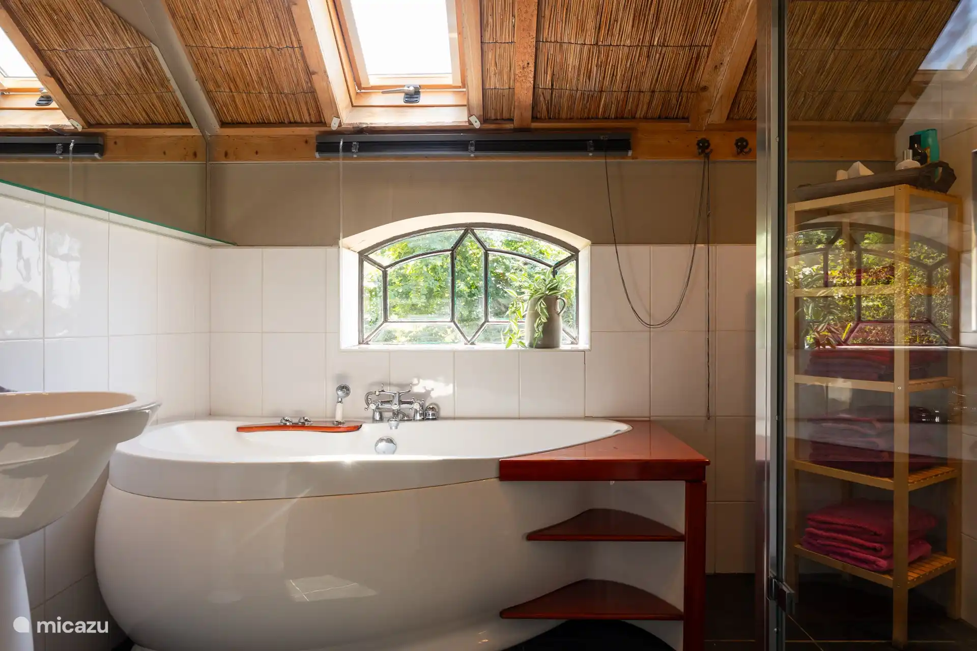 Badezimmer mit Badewanne und Dusche, Waschbecken und Waschmaschine.