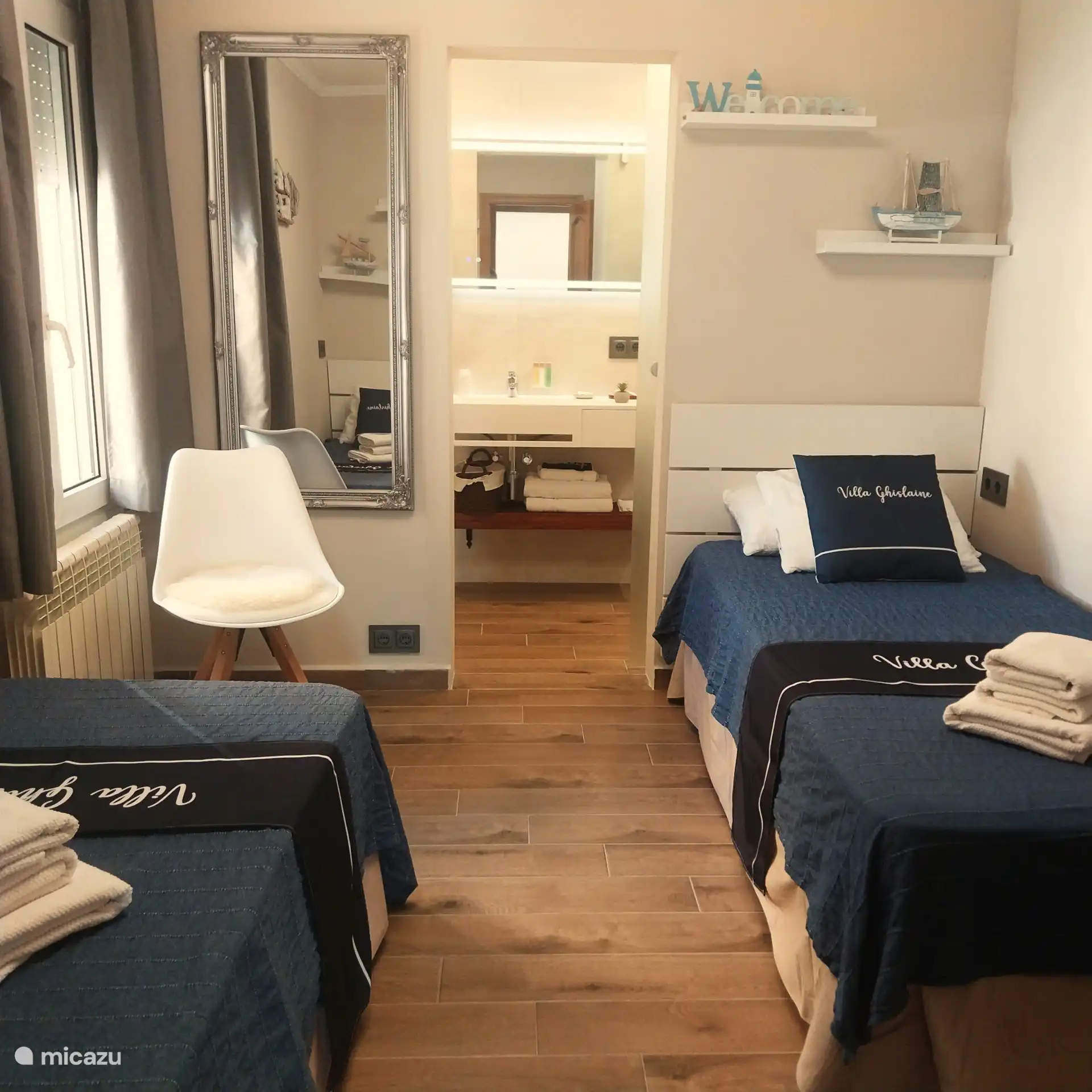 2nd Bedroom, a suite with two single beds, wardrobe, large mirror and direct access to the 2nd bathroom. The room is equipped with air conditioning or fan, according to your choice.