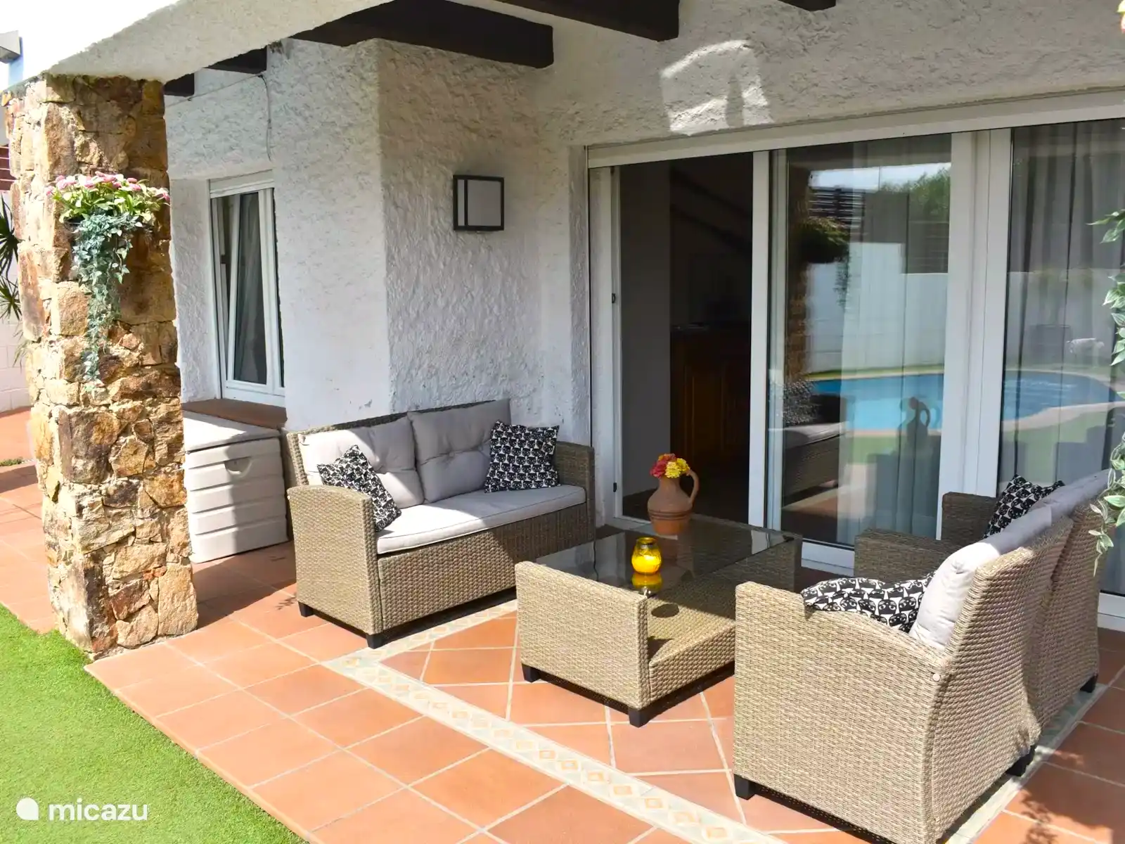 Terrasse mit Gartensitzen neben dem Garten. Ein Ort, um nach einem Bad im Pool im Schatten zu genießen.