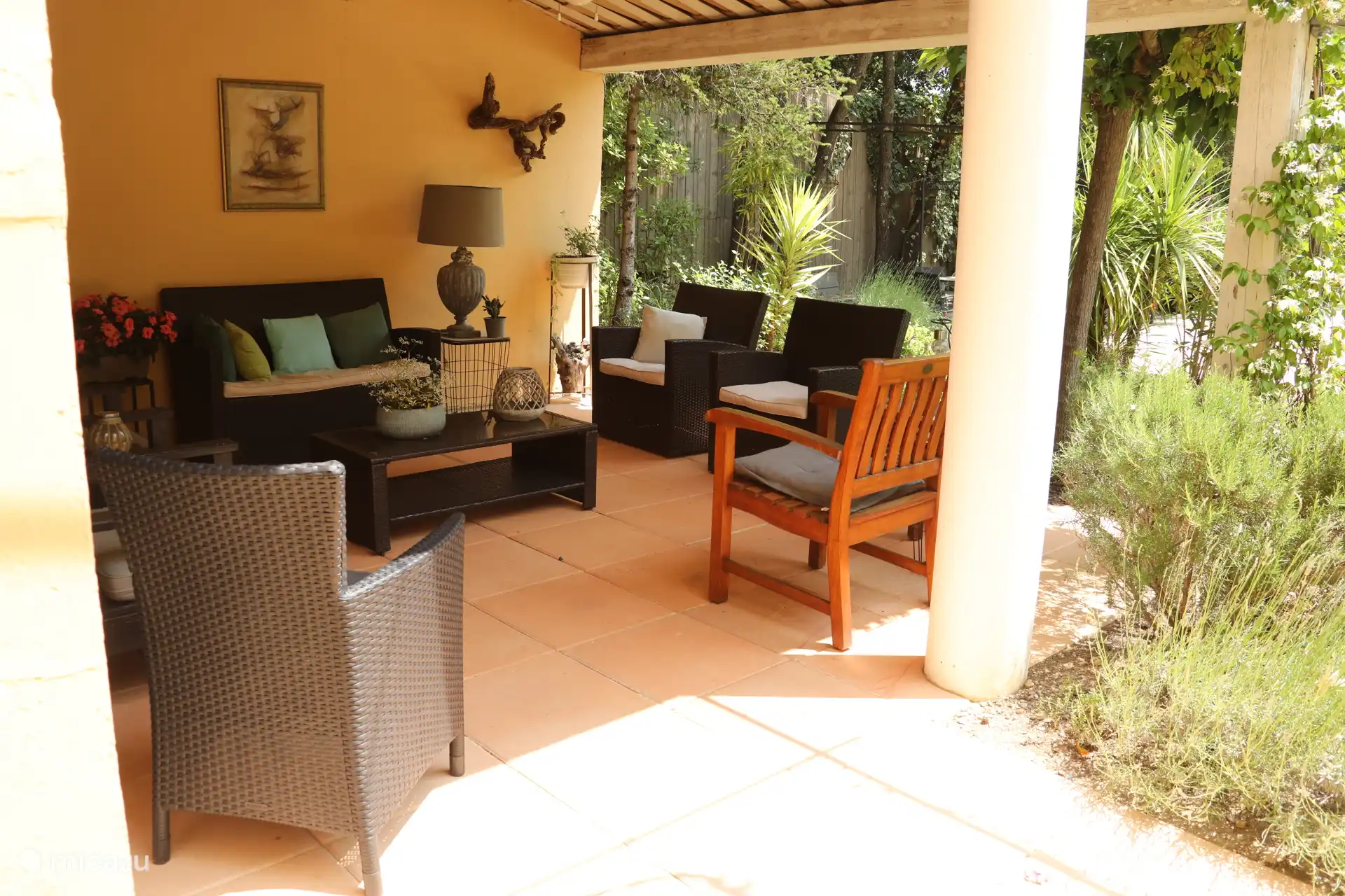 Lounge-Garten 2 mit verschiedenen Sitzbereichen, Deckenventilator, verbundenem Stauraum mit verschiedenen Polstern und Spielgeräten für die Kinder.