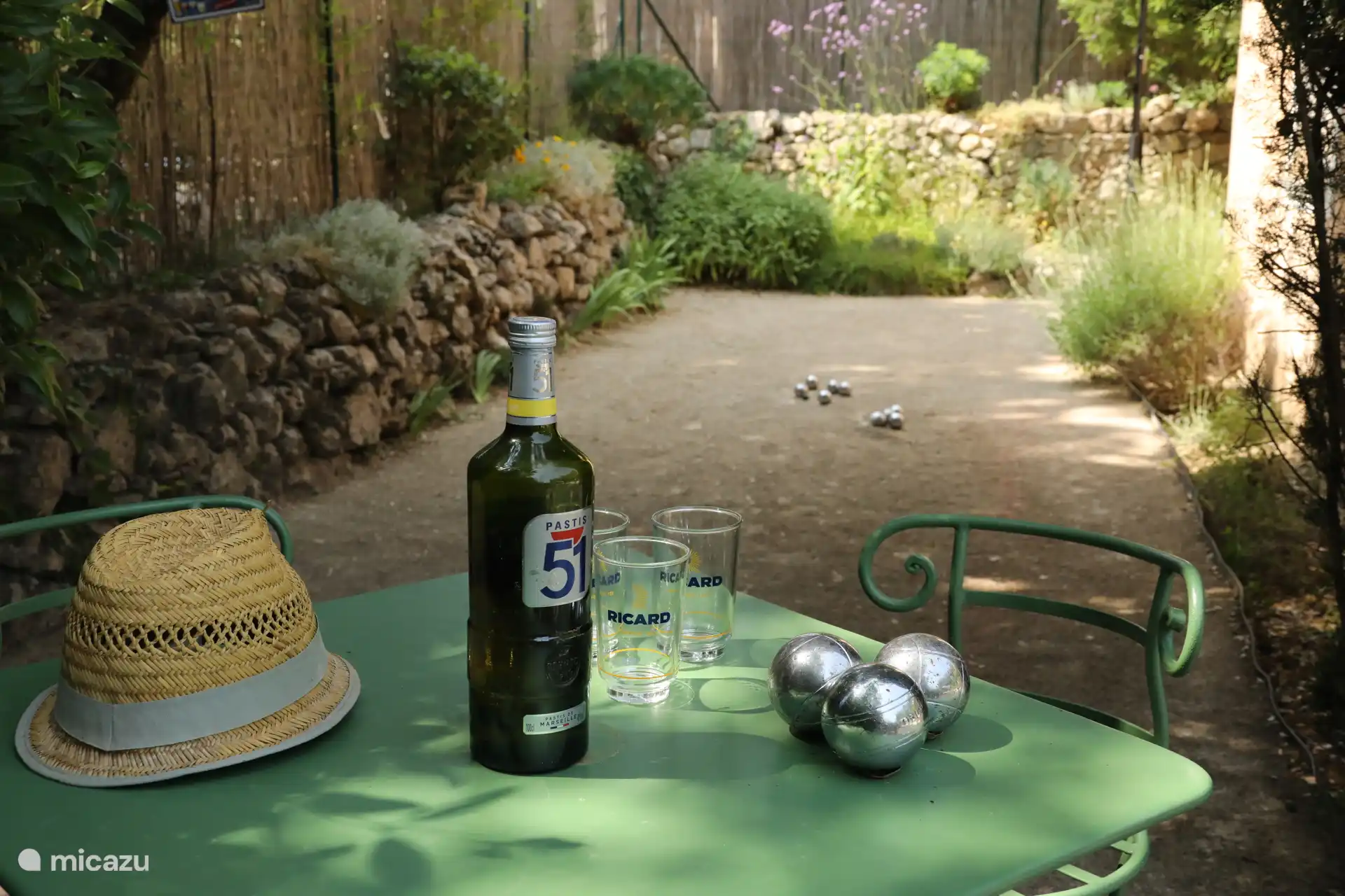 Petanque-Quadrat, Tisch und Stühle sowie Jeu de boulle-Bälle befinden sich im Stall gegenüber der offenen Küche.