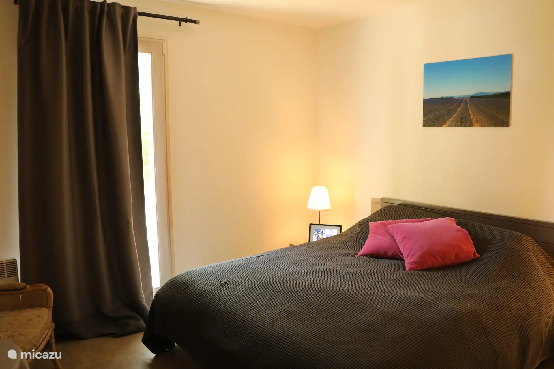 Schlafzimmer 1 (Kingsize-Bett), mit Tisch und 2 Sitzgelegenheiten, Fenstertür zum Garten.