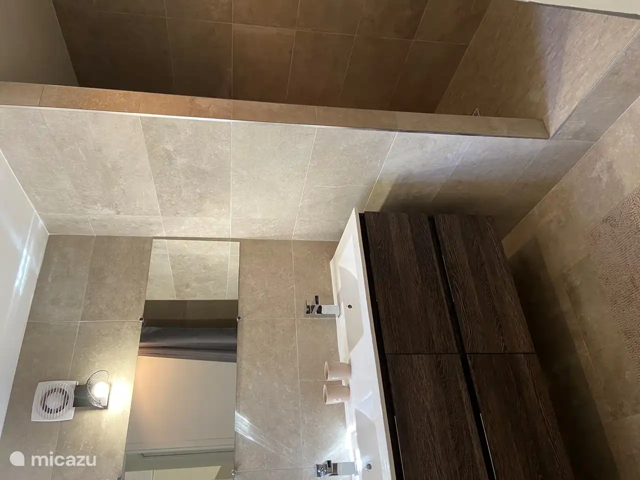 Badezimmer Nummer 1 mit begehbarer Dusche, zwei Waschbecken mit Schubladen, Föhn und separater WC.