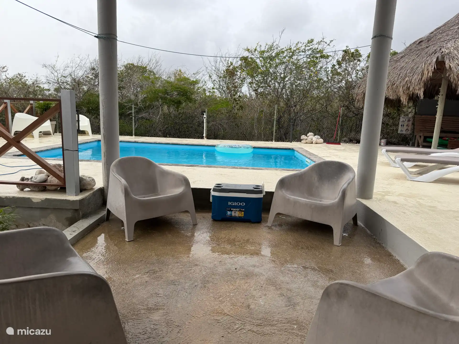 Lugar de descanso a la sombra bajo la terraza junto a la piscina 