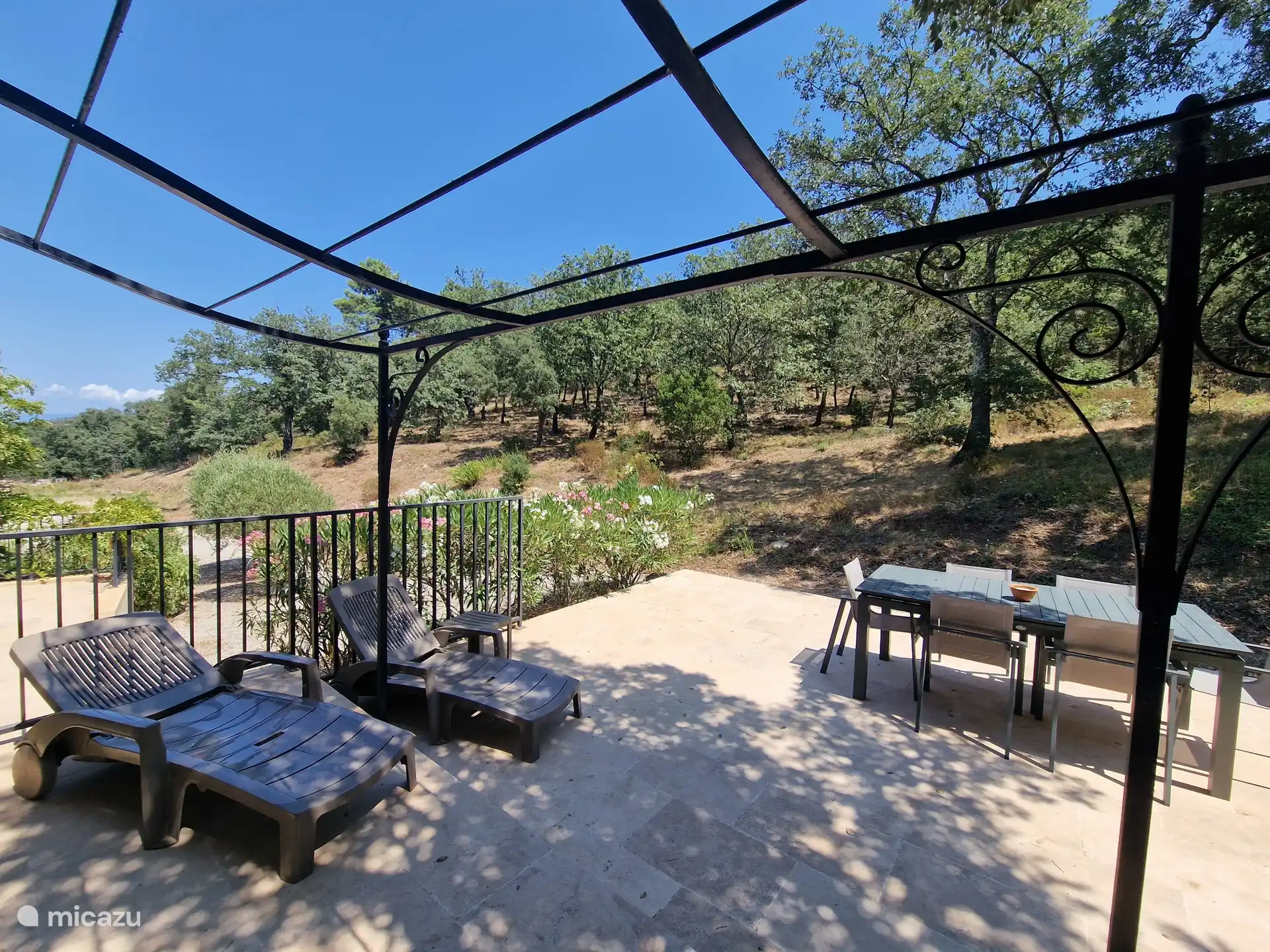 Gran terraza privada con tumbonas y mesa de comedor