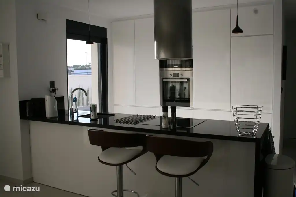 Luxuriöse offene Küche mit allen Annehmlichkeiten und gemütlich mit Barhockern.