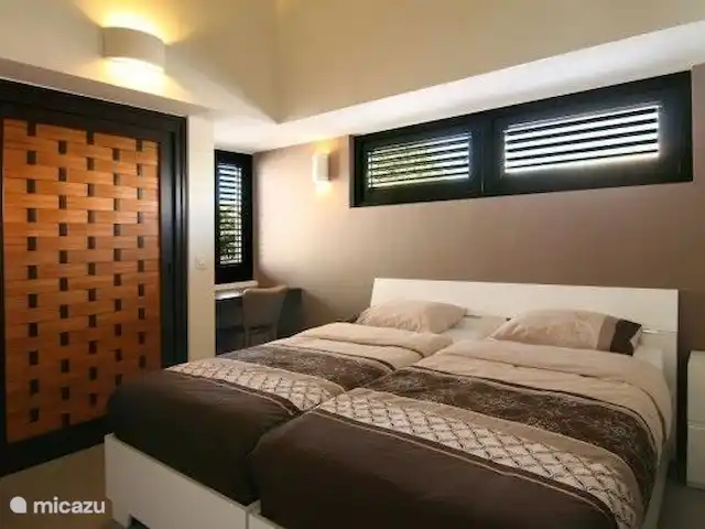 Location de Vacances Curaçao, Curaçao-Centre, Blue Bay, villa - Blue Bay Paradise Deuxième chambre avec salle de bain privée avec WC et placards équipés d'une climatisation, bureau avec chaise.