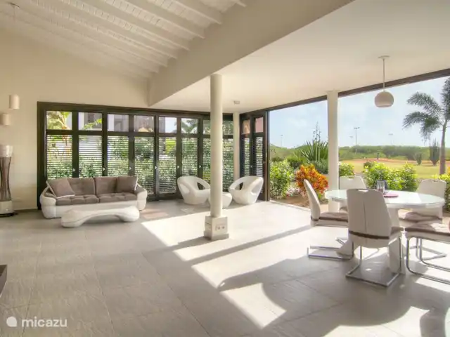 Location de Vacances Curaçao, Curaçao-Centre, Blue Bay, villa - Blue Bay Paradise Le salon. Ces portes à volets offrent une combinaison parfaite de la sensation intime d'être dans un salon tout en ayant le sentiment de pouvoir profiter de l'extérieur. Ils assurent également une parfaite ventilation naturelle de l'habitation.