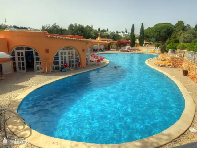 Os Quatros, Quinta do Paraíso | Portugal, Algarve, Carvoeiro - villa Une des trois piscines avec un bar cosy, des chaises longues et des parasols.