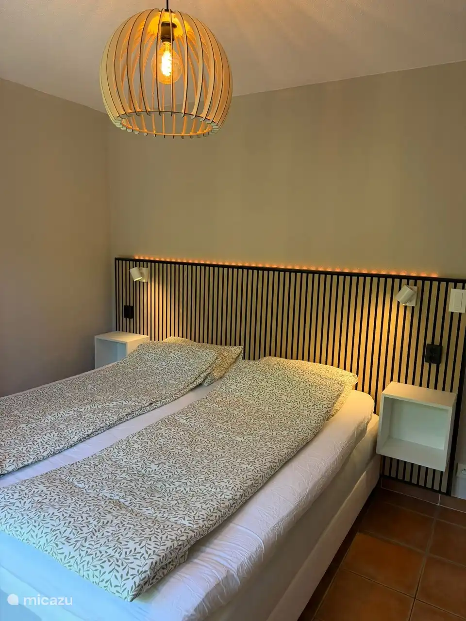Slaapkamer beneden (master bedroom) met luxe boxsprings en sfeervolle inrichting 