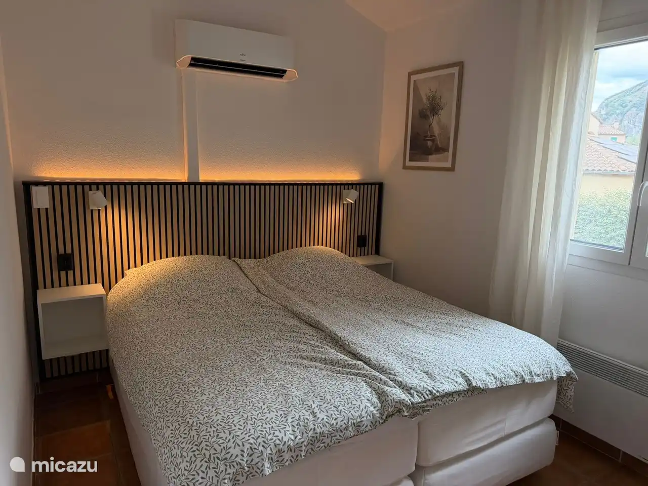 Eén van de twee slaapkamers boven met airco, luxe 2-persoons boxspring bed met comfortabele matrassen en een topdek.