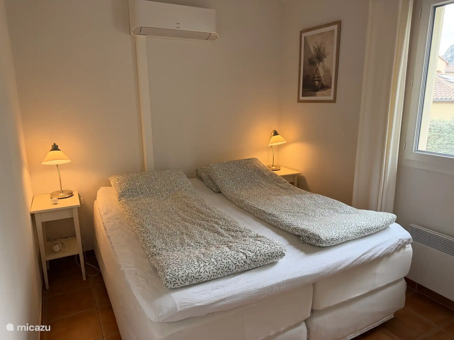 Eén van de twee slaapkamers boven met airco, luxe 2-persoons boxspring bed met comfortabele matrassen en een topdek.