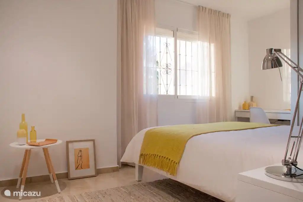 Das gelbe Zimmer! Auch ein Doppelzimmer. Mit leuchtend gelben Details und einem dunklen Rücken. Mit Blick auf Palmen und Felder. Bettgröße 160x200. Großer Kleiderschrank mit Schiebetüren.