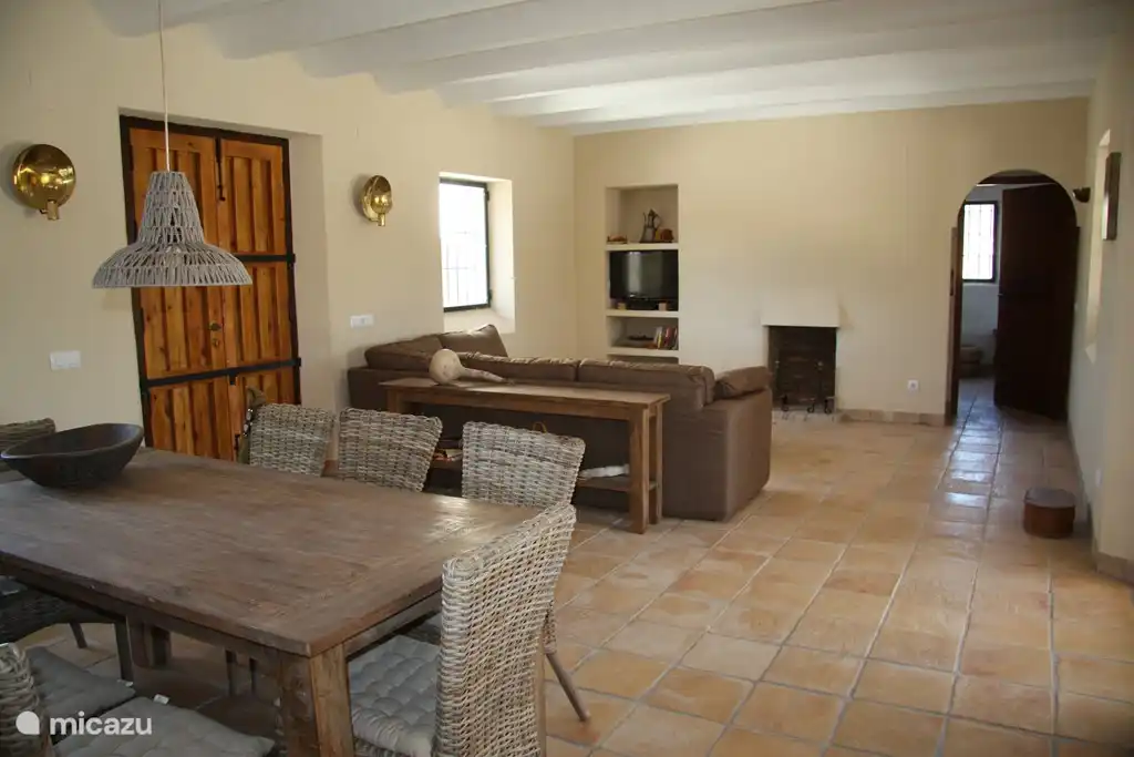 Wohnzimmer mit Essbereich, loungbank, TV und Kamin.