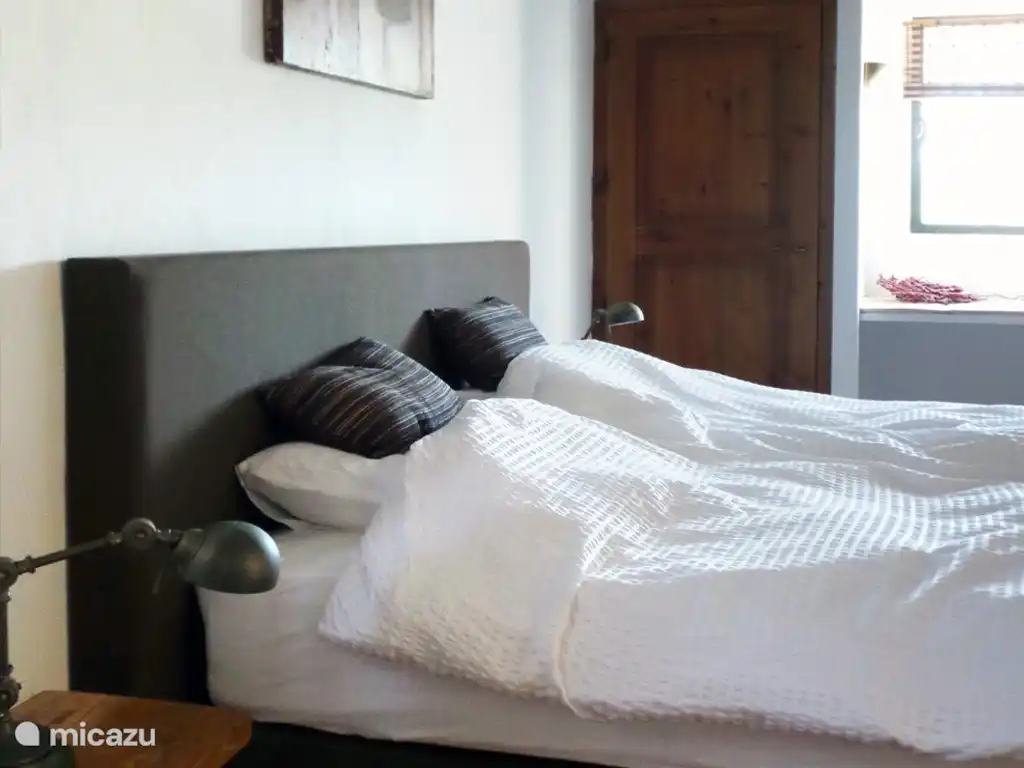 Erdgeschoss: Schlafzimmer mit airo mit Boxspring (180x200 cm) und Badezimmer en suite.